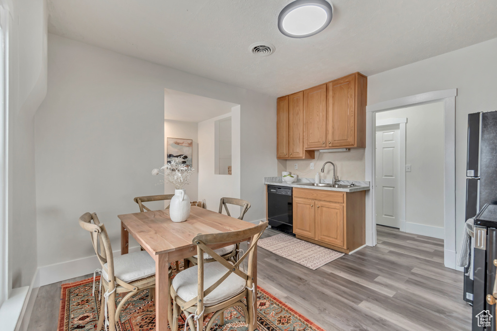 Dining space featuring visible vents, light wood-style flooring, and baseboards