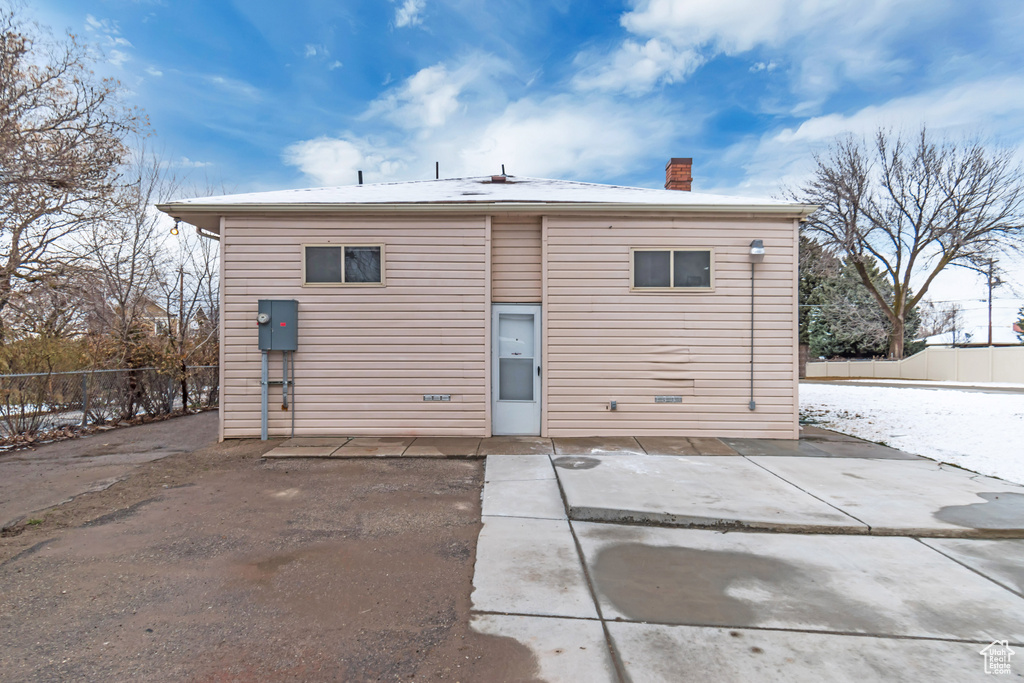 Back of house featuring a chimney, a patio, and fence