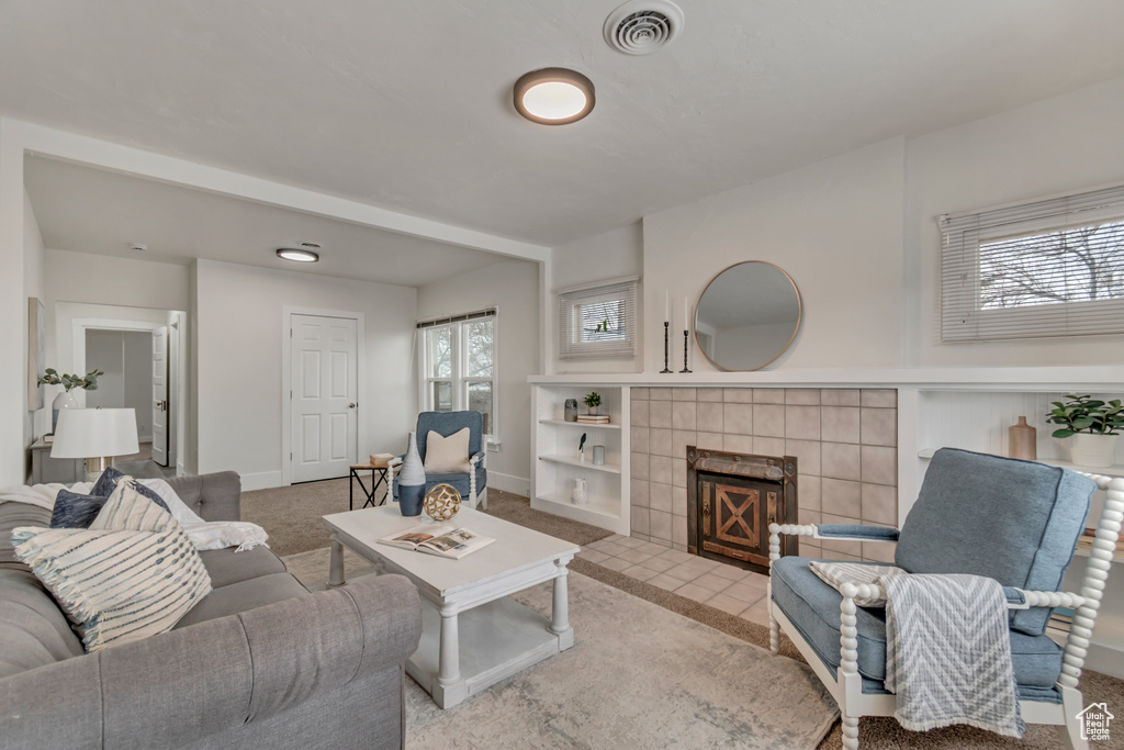 Living room with visible vents, carpet floors, baseboards, and a fireplace