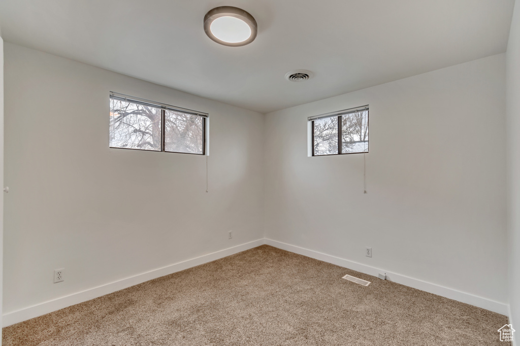 Spare room with visible vents, carpet flooring, and baseboards