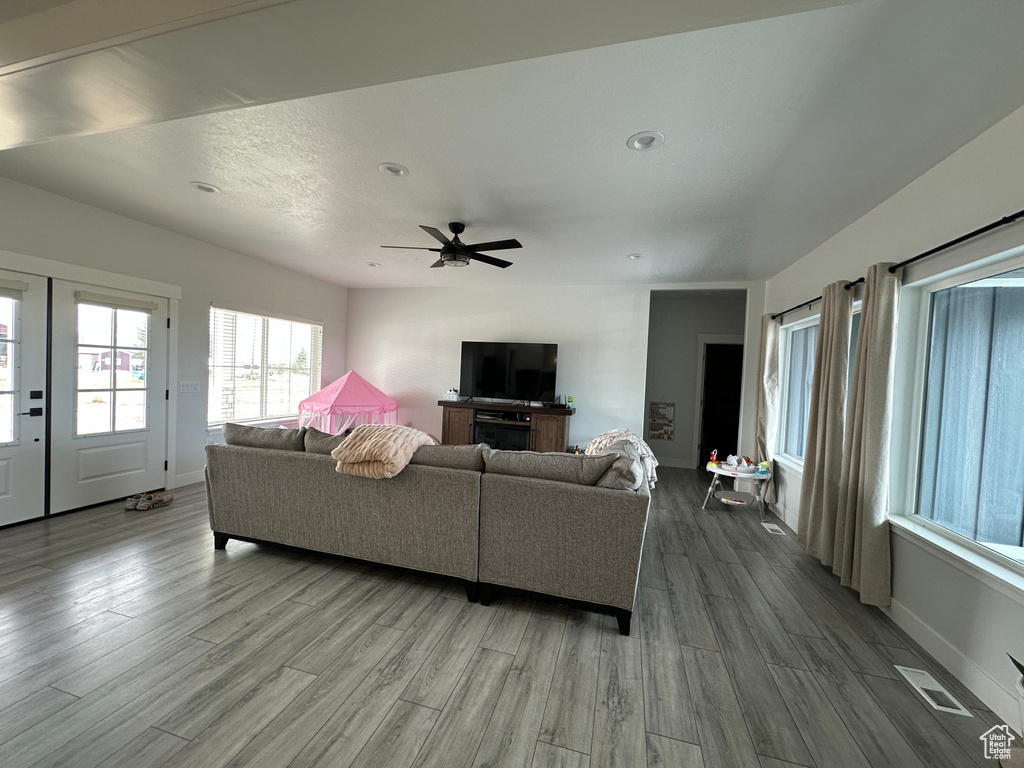 Living room with visible vents, baseboards, and wood finished floors