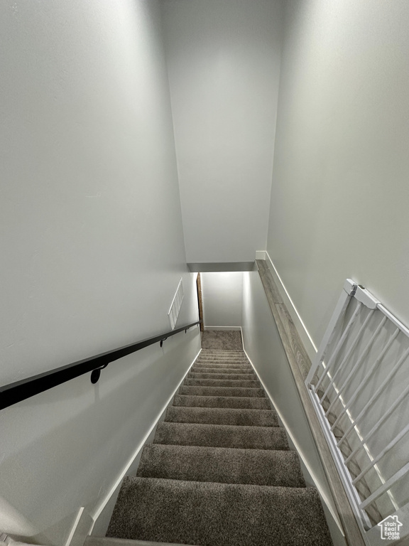 Staircase featuring carpet flooring, visible vents, and baseboards