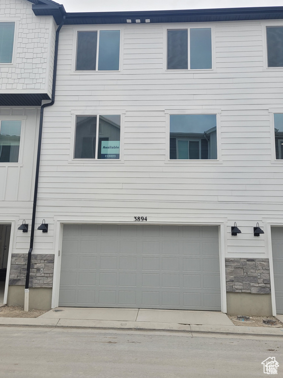 View of front of house featuring stone siding and a garage