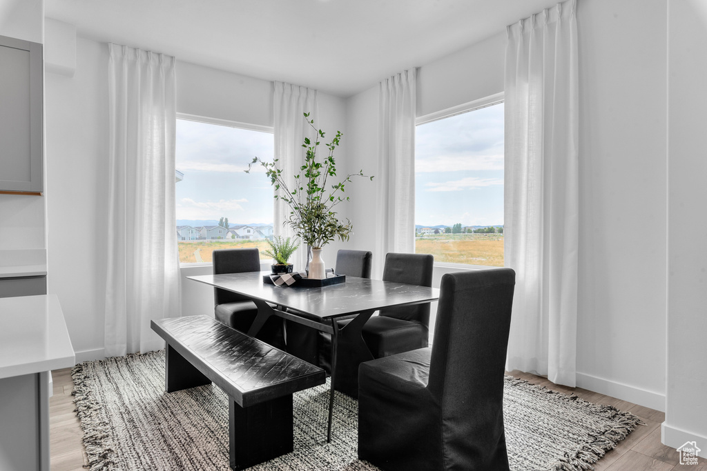 Dining area with light wood-style floors and baseboards