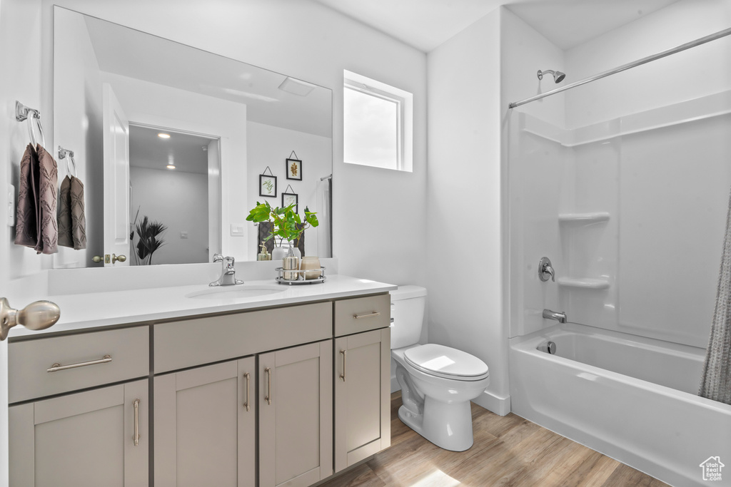 Full bath with vanity,  shower combination, toilet, and wood finished floors