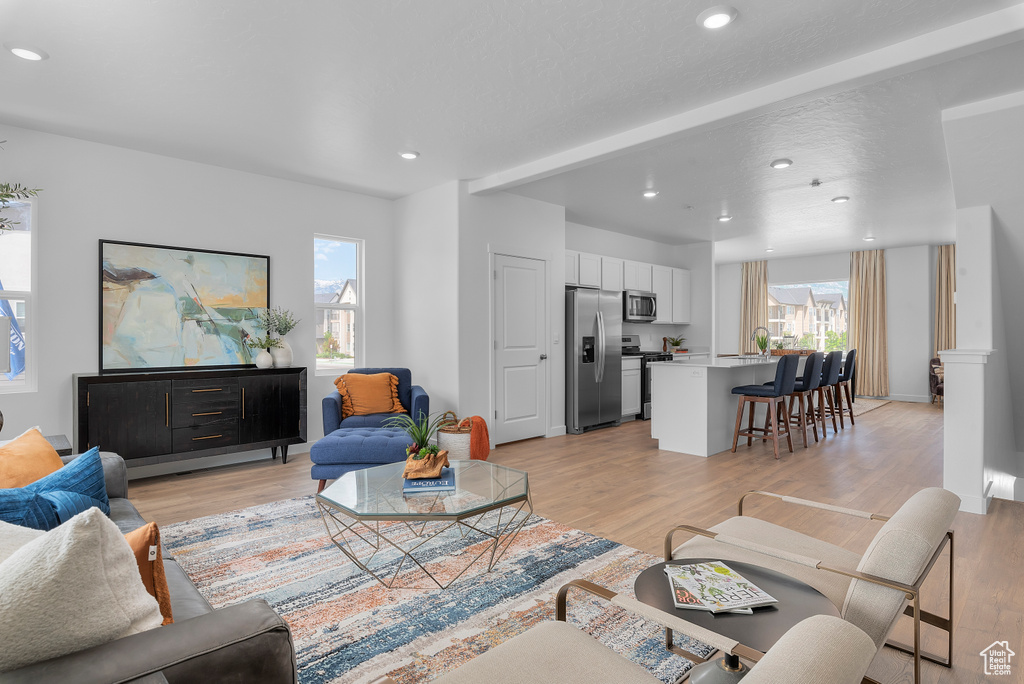 Living area featuring recessed lighting, baseboards, and light wood-style flooring