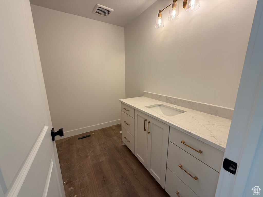 Bathroom featuring visible vents, baseboards, wood finished floors, and vanity