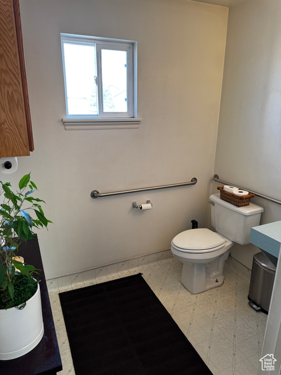 Half bathroom featuring toilet and baseboards