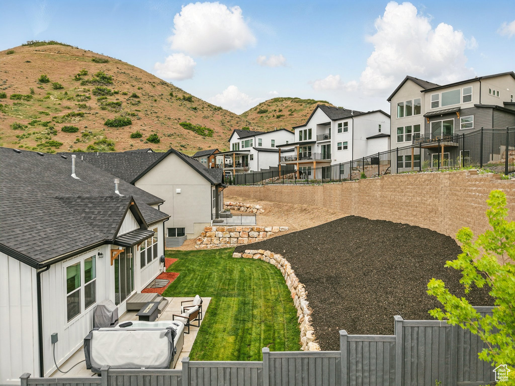 Fenced backyard with a residential view, a mountain view, and a patio area