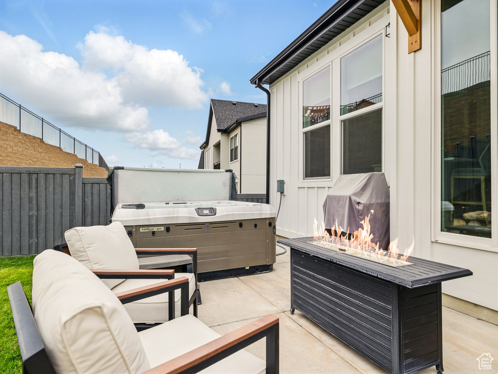 View of patio featuring a hot tub, area for grilling, and fence