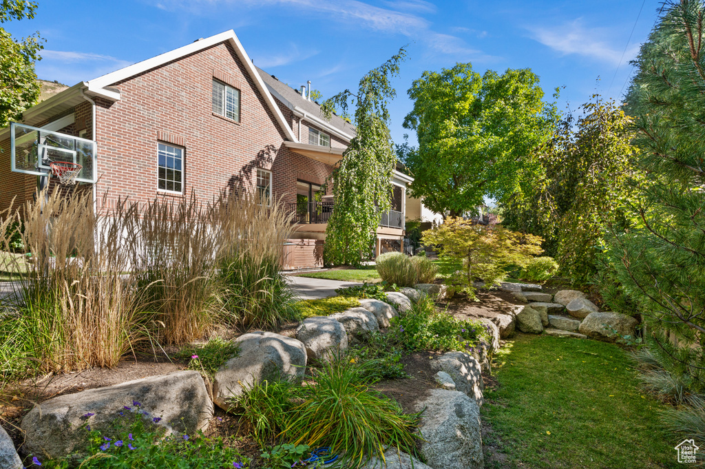Exterior space with cooling unit, brick siding, and a yard