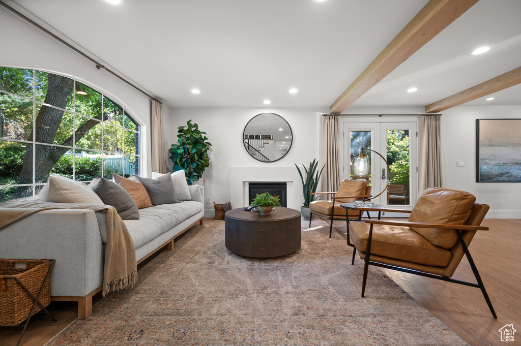 Living room featuring wood finished floors, beamed ceiling, plenty of natural light, and a fireplace