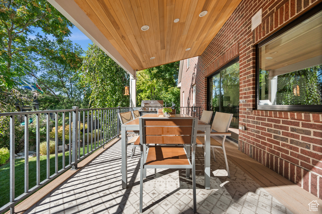 Deck with outdoor dining space and a grill