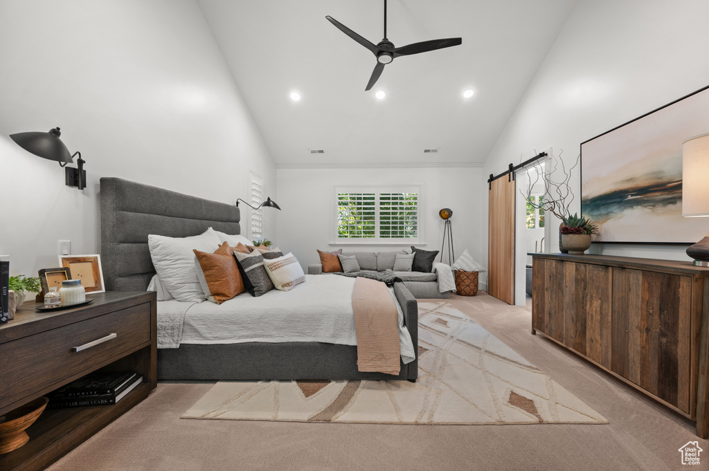 Bedroom with recessed lighting, a barn door, light colored carpet, and high vaulted ceiling