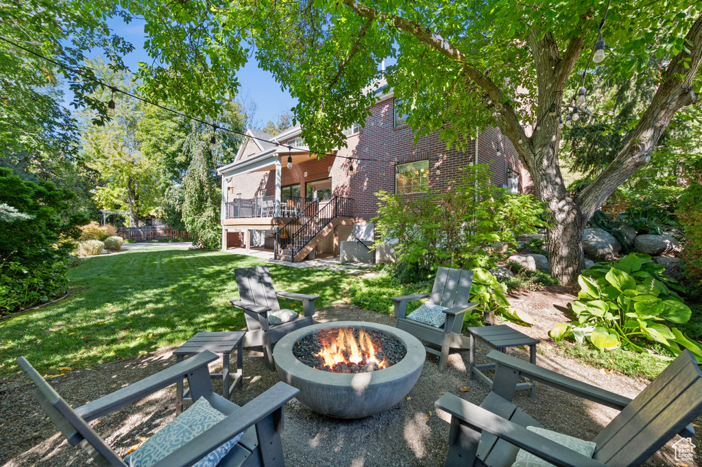 View of patio with stairs, a deck, and an outdoor fire pit