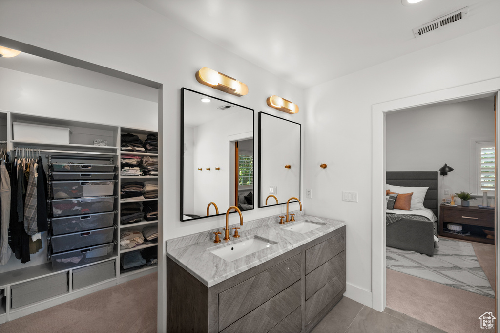 Ensuite bathroom with double vanity, visible vents, ensuite bathroom, and a sink