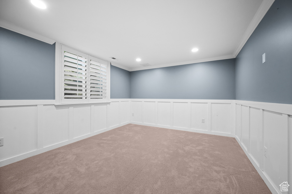 Carpeted spare room featuring crown molding, recessed lighting, visible vents, and wainscoting