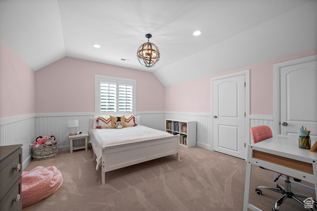 Bedroom featuring vaulted ceiling, light colored carpet, and wainscoting