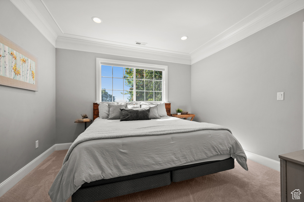 Carpeted bedroom featuring recessed lighting, visible vents, baseboards, and ornamental molding