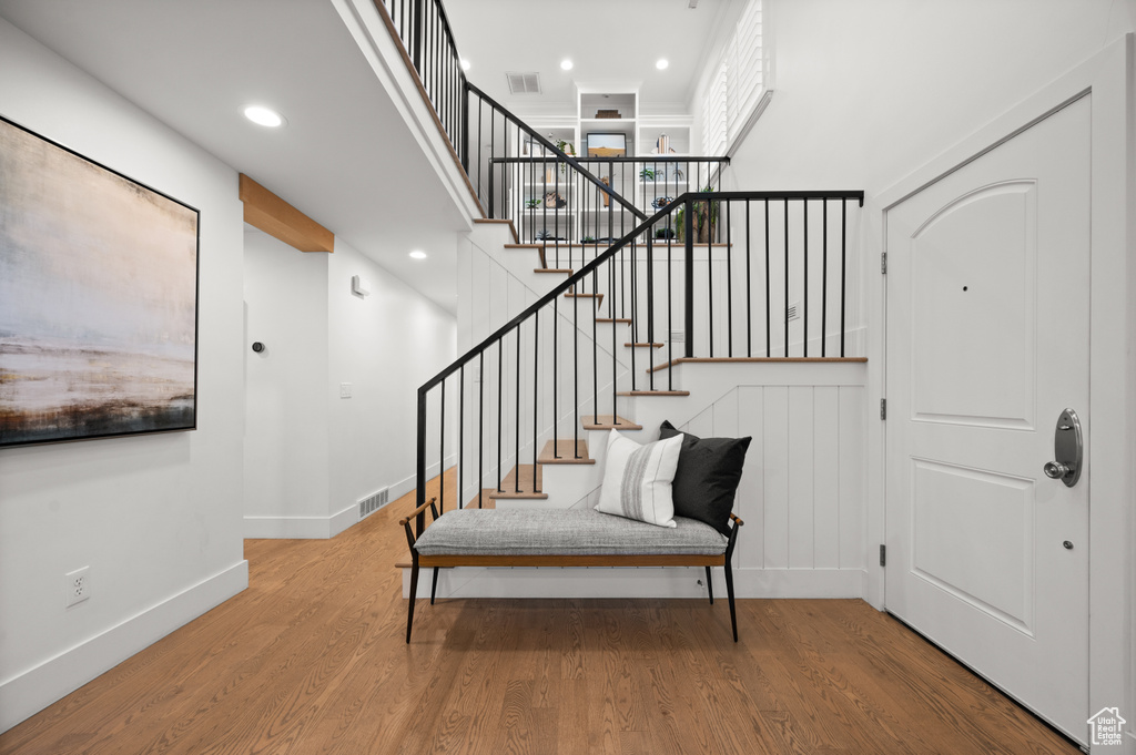 Foyer entrance with recessed lighting, a high ceiling, baseboards, and wood finished floors