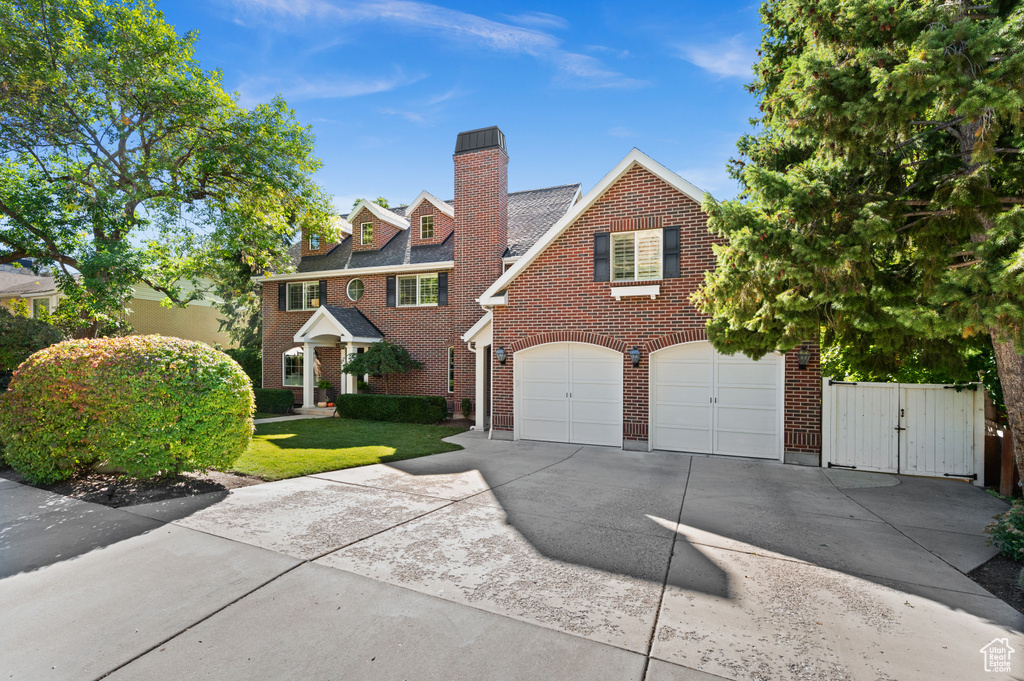 View of front of home with concrete driveway, an attached garage, and brick siding