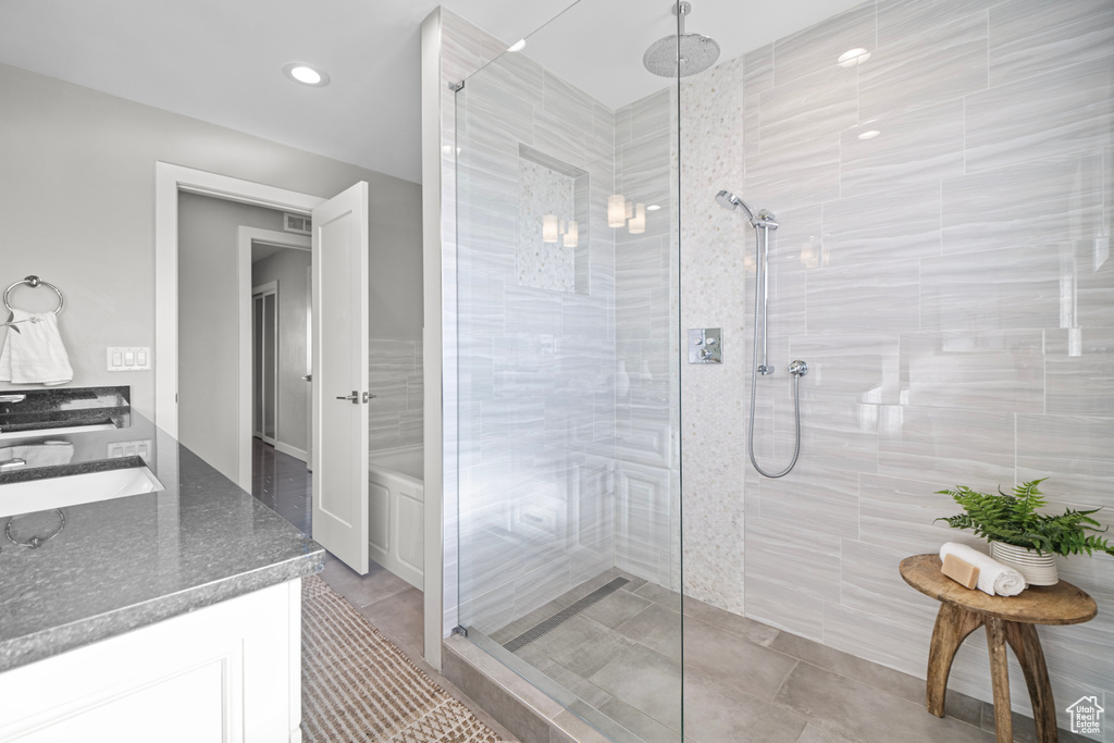 Bathroom featuring visible vents, a walk in shower, and vanity
