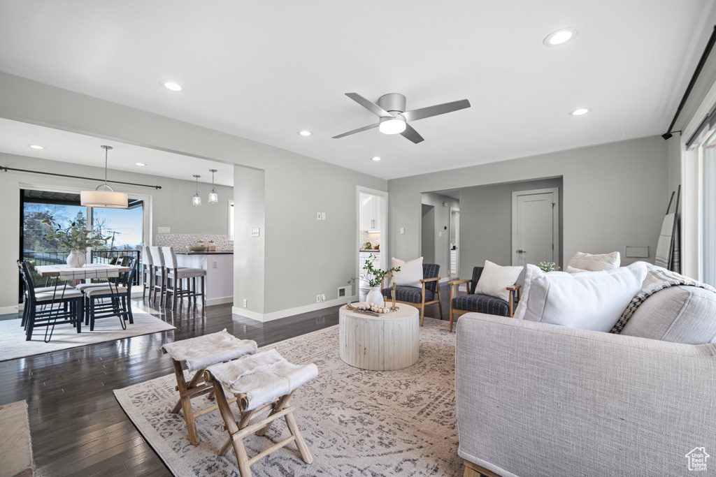 Living room with dark wood finished floors, recessed lighting, a ceiling fan, and baseboards