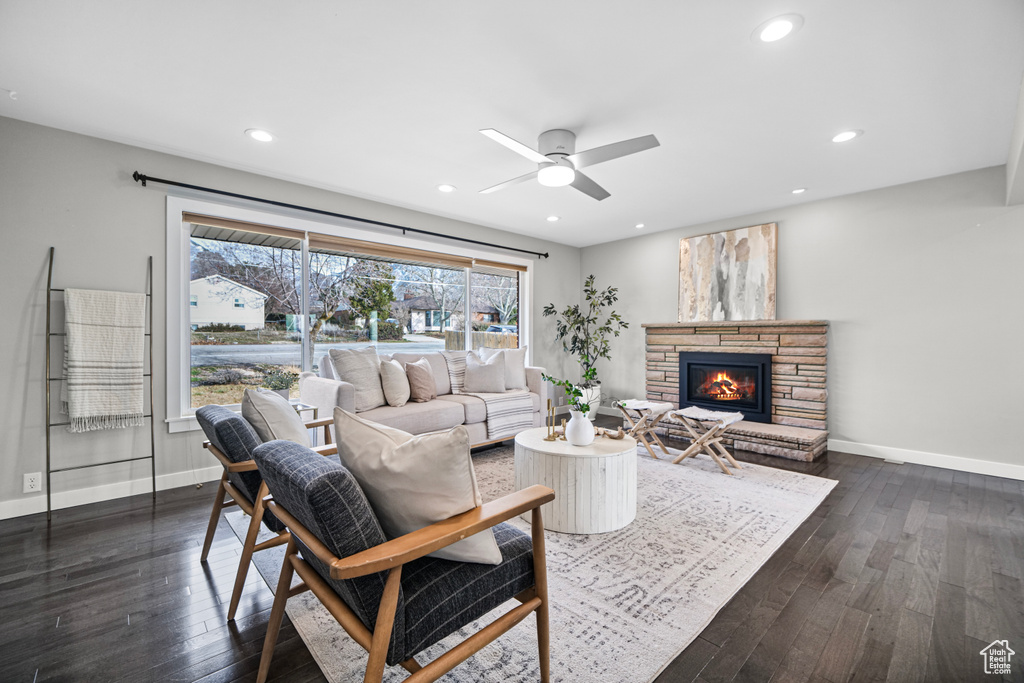 Living room featuring dark wood finished floors, a fireplace, and baseboards