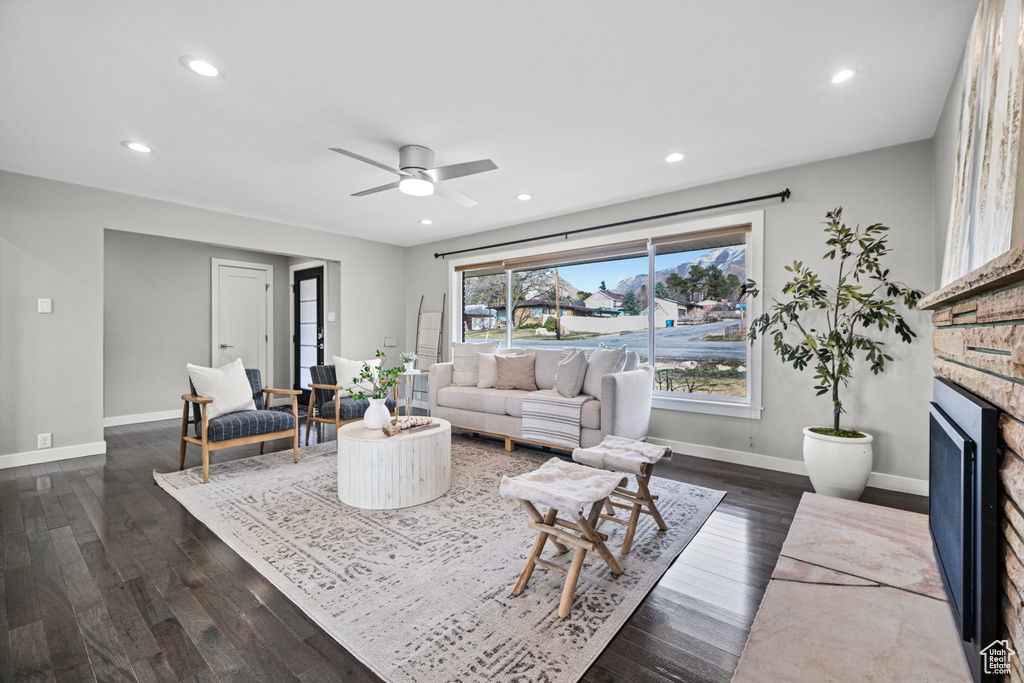 Living room with recessed lighting, baseboards, dark wood-style floors, and a fireplace