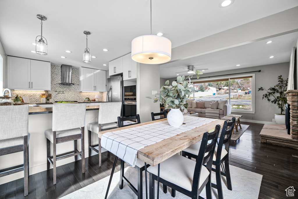 Dining room featuring dark wood-style floors, baseboards, a fireplace, recessed lighting, and ceiling fan
