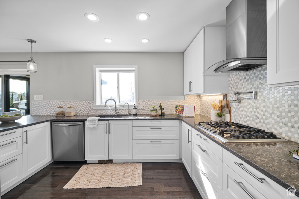 Kitchen featuring plenty of natural light, appliances with stainless steel finishes, wall chimney exhaust hood, and a sink