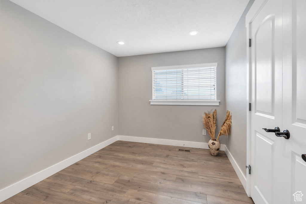 Unfurnished room with baseboards, wood finished floors, and recessed lighting