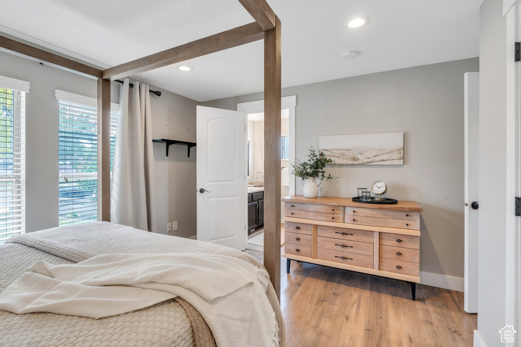 Bedroom featuring light wood-type flooring, baseboards, recessed lighting, and ensuite bathroom