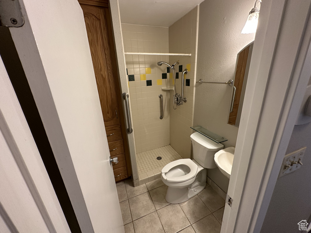 Bathroom with a shower stall and tile patterned flooring