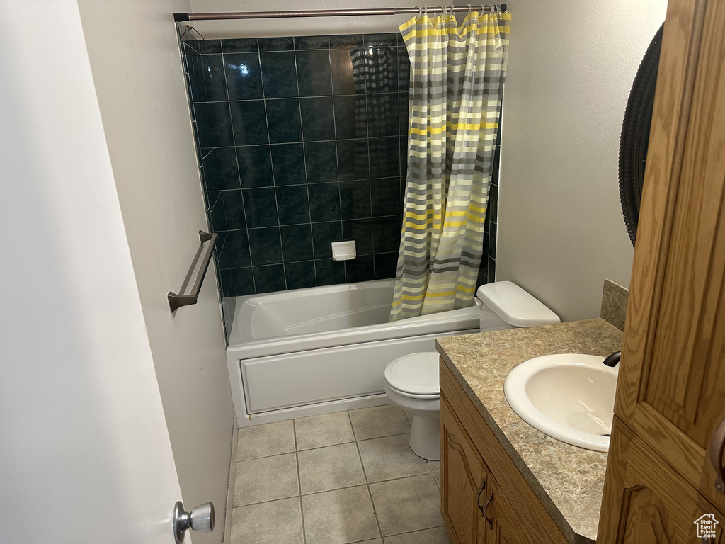 Bathroom with tile patterned floors, shower / tub combo with curtain, and vanity