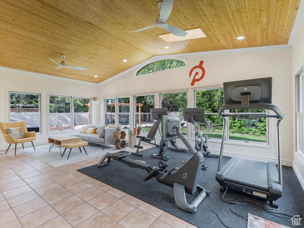 Exercise room with a skylight, high vaulted ceiling, ceiling fan, and wood ceiling