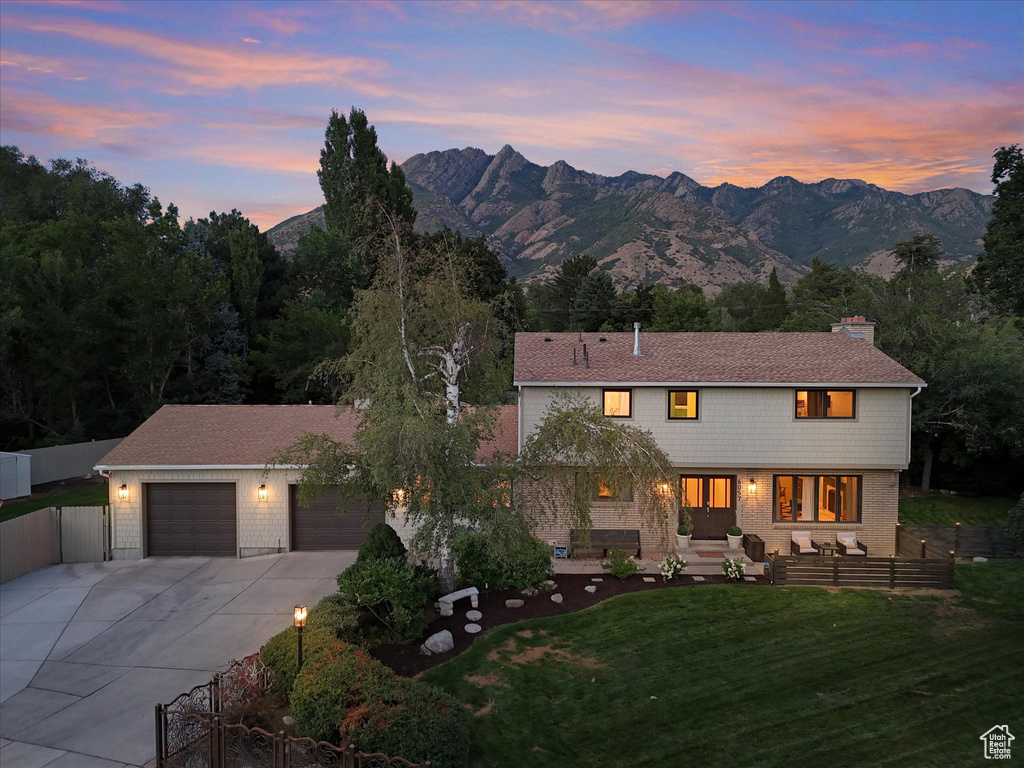 View of front of house with a lawn, a mountain view, and a garage