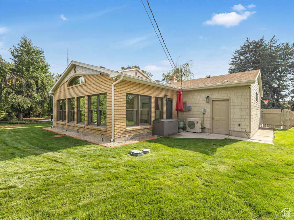 Rear view of property featuring ac unit, a yard, and a patio area