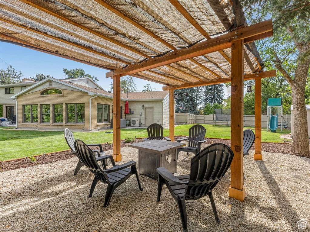 View of patio with a pergola, a playground, and an outdoor fire pit