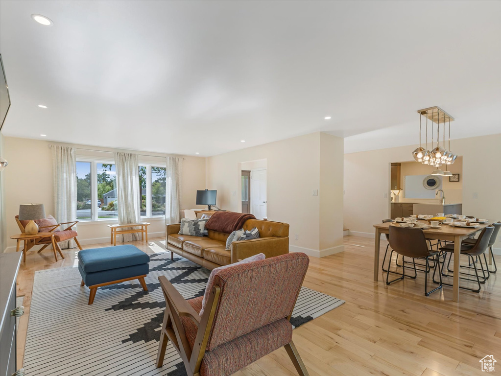 Living room with an inviting chandelier and light hardwood / wood-style flooring