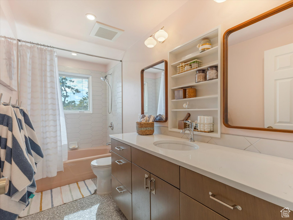 Full bathroom featuring shower / tub combo with curtain, vanity, and toilet