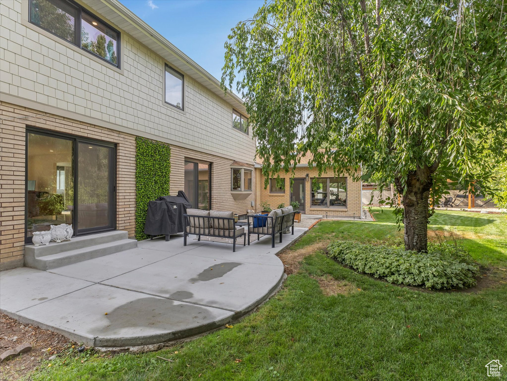 Exterior space with an outdoor hangout area, a patio area, and a lawn