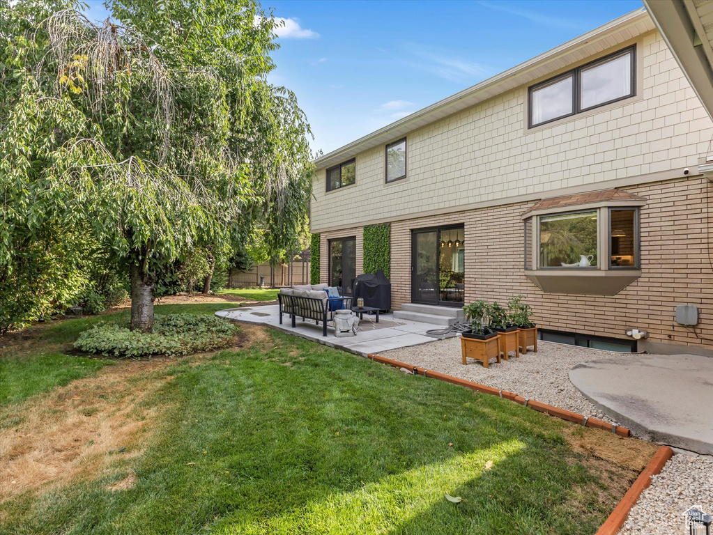 Back of house featuring outdoor lounge area, a yard, and a patio