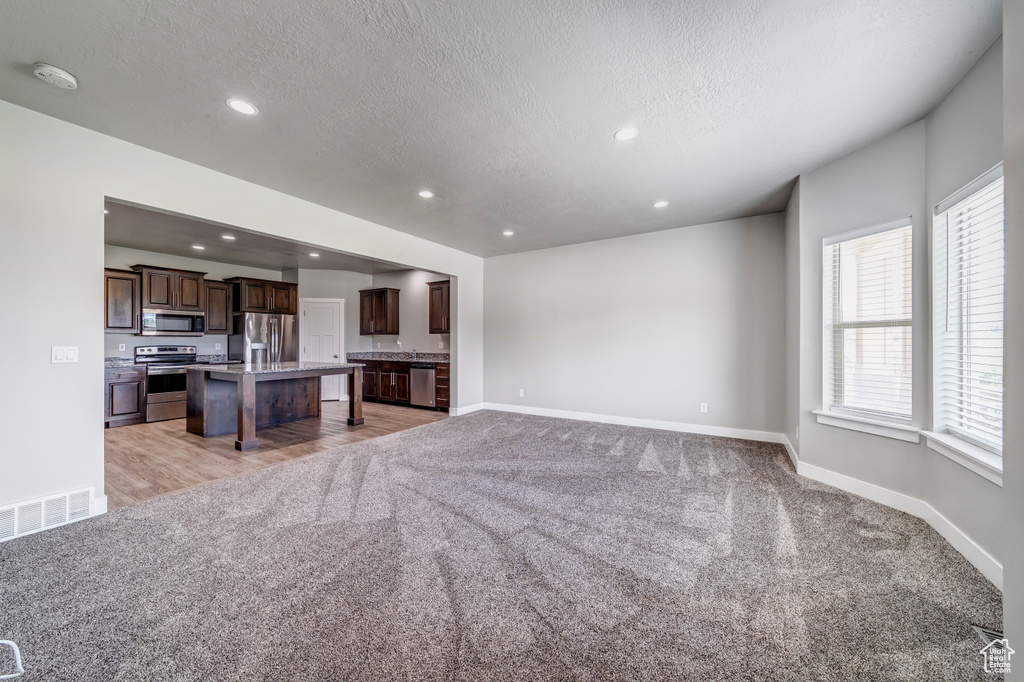 Living area featuring recessed lighting, baseboards, and light colored carpet