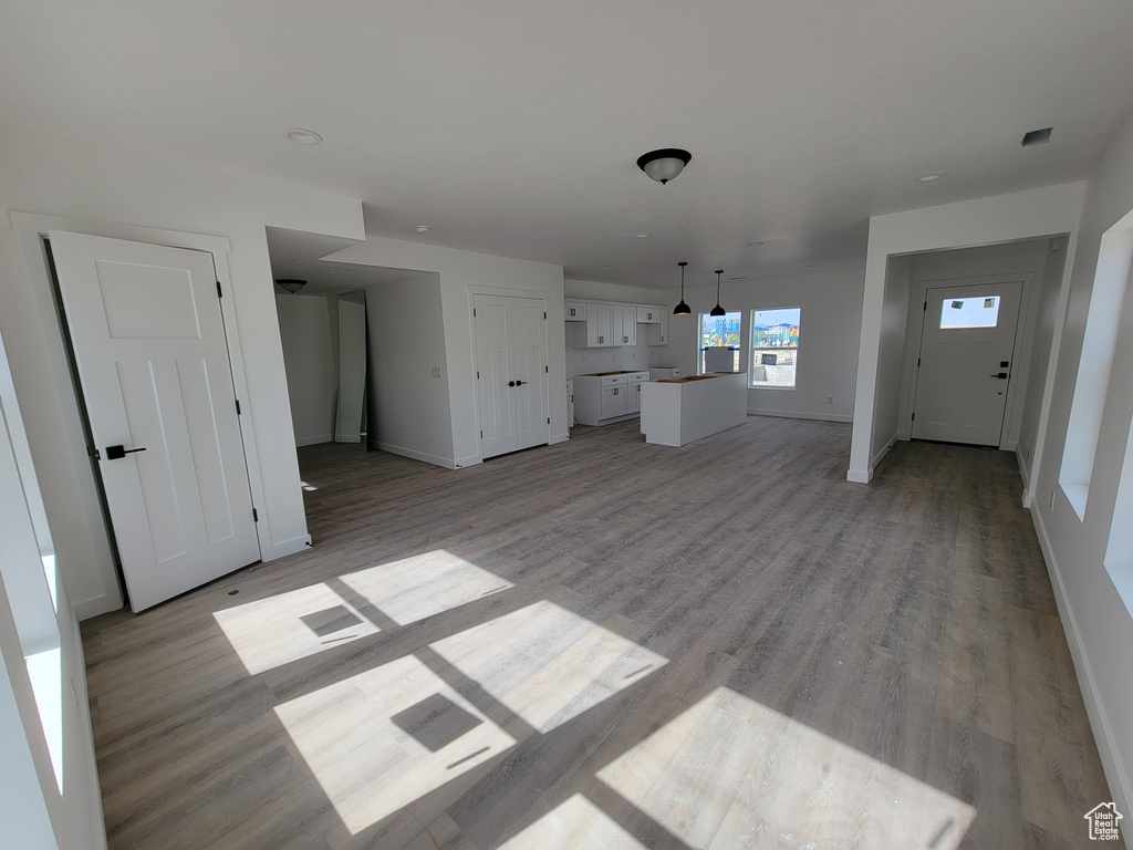 Unfurnished living room with baseboards and light wood finished floors