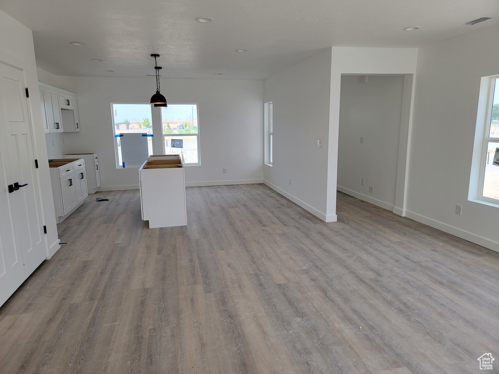Kitchen with white cabinets, light wood-style flooring, baseboards, and recessed lighting