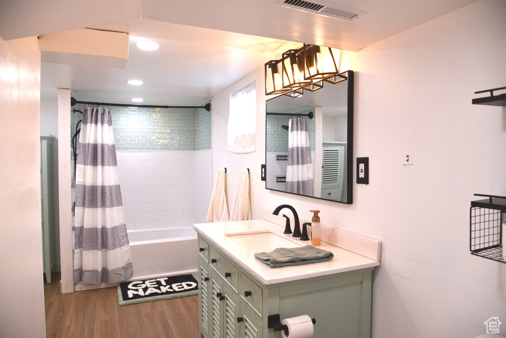 Full bath featuring vanity, wood finished floors, visible vents, recessed lighting, and shower / bath combo