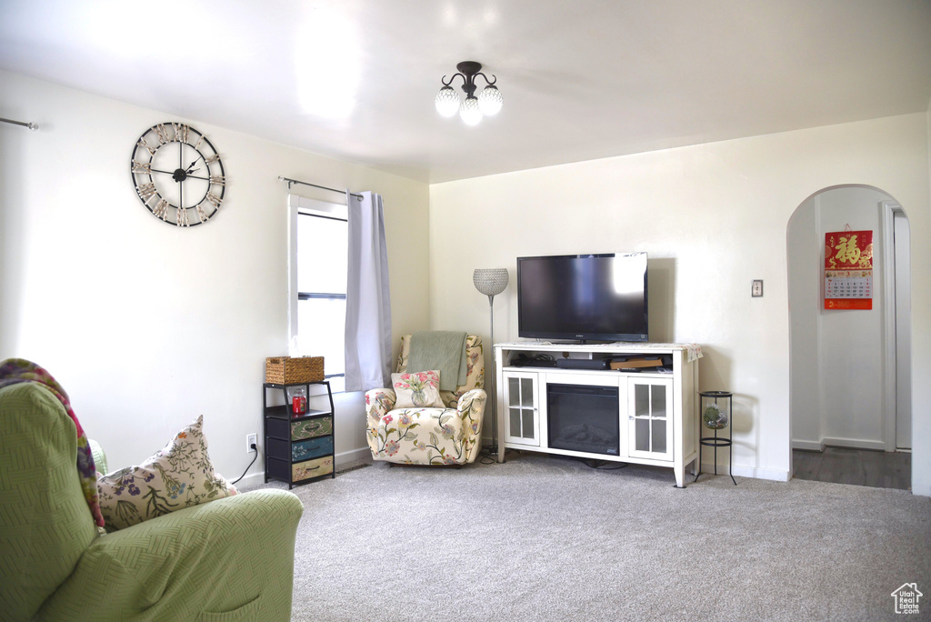 Living area featuring arched walkways and carpet flooring