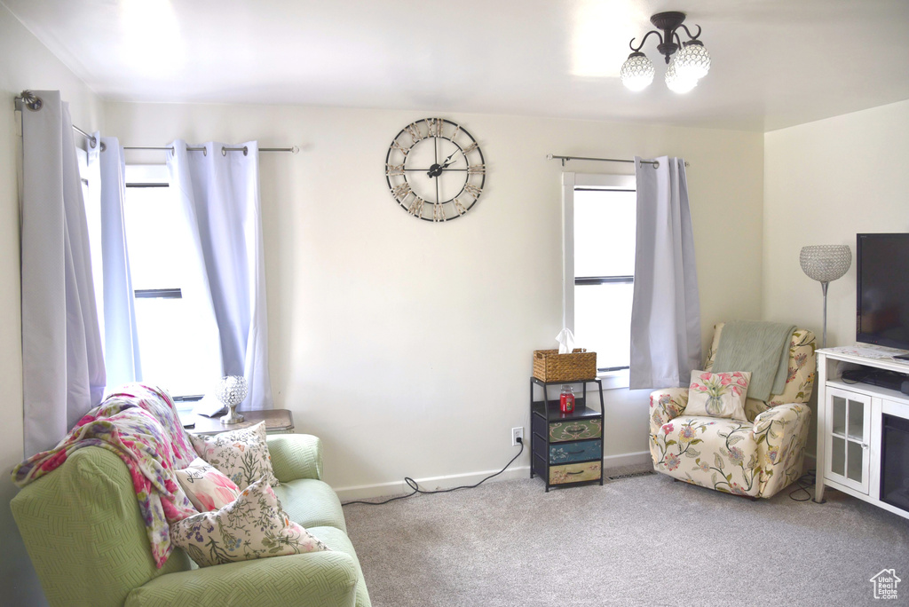 Sitting room with carpet, baseboards, and a chandelier