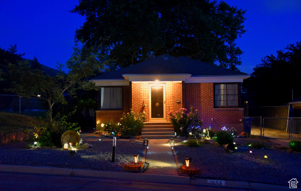 View of front of house featuring brick siding and a gate